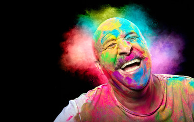Bald smiling man with colorful face having fun. Colors festival