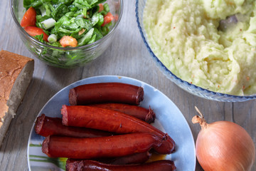 Grilled traditional homemade smoked sausage with salad and mashed potato