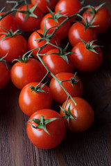 bunch of tomatoes on branch on classic wooden board