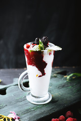 Glasses of fresh cold smoothie with fruit and berries on wooden flat and dark background