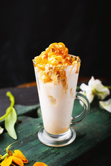 A caramel milkshake in glass on wooden flat  and dark background
