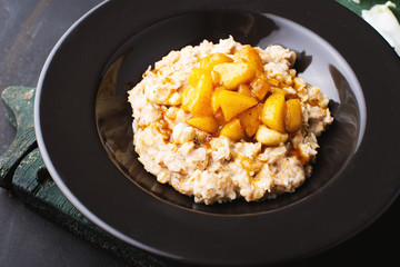 Breakfast, morning porridge with milk and delicious melon iin dark plate