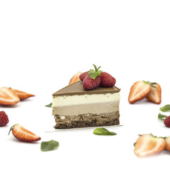 chocolate cake with white chocolate on a white plate with strawberries and mint