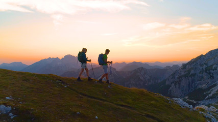 AERIAL: Carefree active woman and man enjoy a calm hike in the serene mountains.