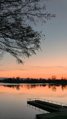 red sunset over the water of a village lake