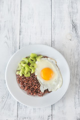 Portion of red quinoa with fried egg and celery