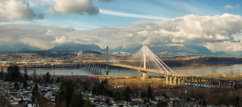 Panoramic view of Port Mann going across Fraser River during a sunny winter day. Taken in Surrey, Vancouver, British Columbia, Canada.
