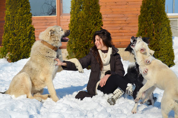 Beautiful Smiling Woman Playing with her Dogs Outdoor in the  Winter.Owner and Dogs Happy Together 