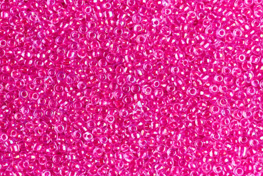Background texture of transparent pink beads close-up.