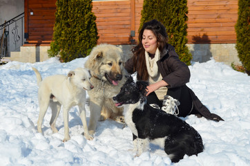 Beautiful Smiling Woman Playing with her Caucasian Shepherd Dog Outdoor in the  Winter.Owner and Dog Happy Together 