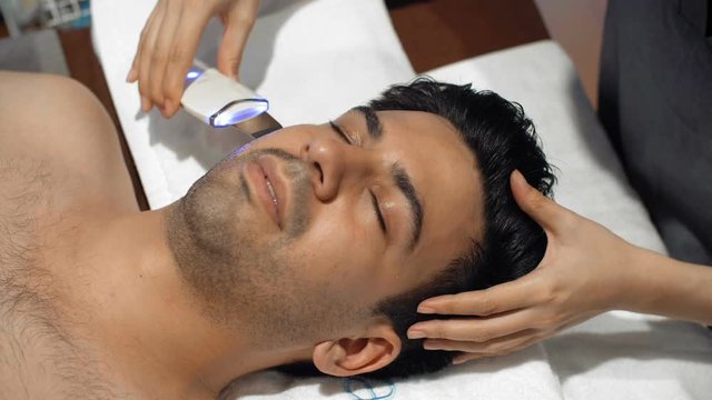 Close up of male face having anti-aging skin stimulation with special equipment