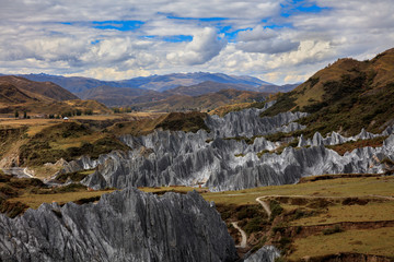 Bamei stone forest, exotic pillars of gray stone situated in the grasslands of Sichuan Province, China. Unique rock formations with clouds in the distant background. Kangding and Xinduqiao scenery