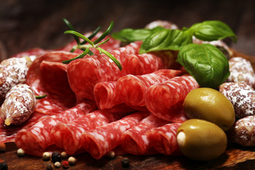 thinly sliced salami on a wooden texture on the background.