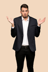 Handsome business man unhappy because not understand something over ocher background