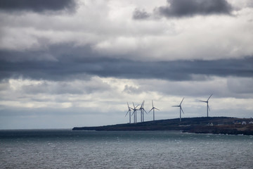 Fototapeta na wymiar Wind Turbine on the ocean coast during a cloudy day. Taken in New Victoria, Nova Scotia, Canada.