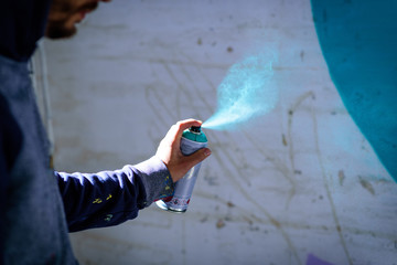 Joven con pintura en aerosol para pintar en pared 21