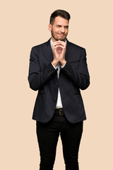 Handsome business man scheming something over ocher background