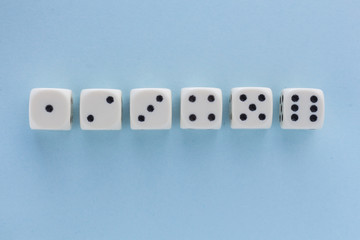 White gaming dices on light blue background. victory chance, lucky. Flat lay, place for text. Top view. Close-up. Concept gamble. spectacular pastel