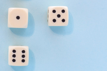 White gaming dices on light blue background. victory chance, lucky. Flat lay, place for text. Top view. Close-up. Concept gamble. spectacular pastel