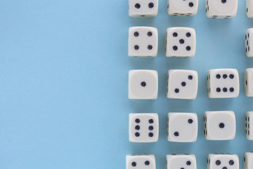 White gaming dices on light blue background. victory chance, lucky. Flat lay, place for text. Top view. Close-up. Concept gamble. spectacular pastel