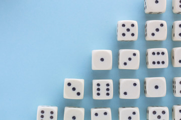 White gaming dices on light blue background. victory chance, lucky. Flat lay, place for text. Top view. Close-up. Concept gamble. spectacular pastel