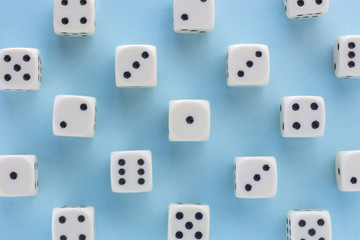 White gaming dices on light blue background. victory chance, lucky. Flat lay, place for text. Top view. Close-up. Concept gamble. spectacular pastel