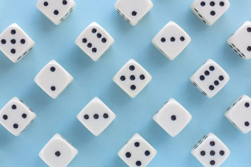 White gaming dices on light blue background. victory chance, lucky. Flat lay, place for text. Top view. Close-up. Concept gamble. spectacular pastel