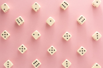 White gaming dices on pink background. victory chance, lucky. Flat lay, place for text. Top view. Close-up. Concept gamble. spectacular pastel