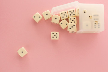 White gaming dices on pink background. victory chance, lucky. Flat lay, place for text. Top view. Close-up. Concept gamble. spectacular pastel