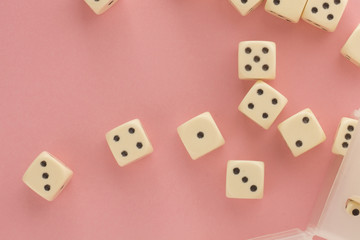 White gaming dices on pink background. victory chance, lucky. Flat lay, place for text. Top view. Close-up. Concept gamble. spectacular pastel