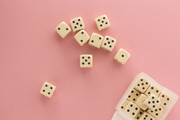 White gaming dices on pink background. victory chance, lucky. Flat lay, place for text. Top view. Close-up. Concept gamble. spectacular pastel