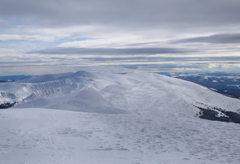 Winter landscape with mountains and clouds