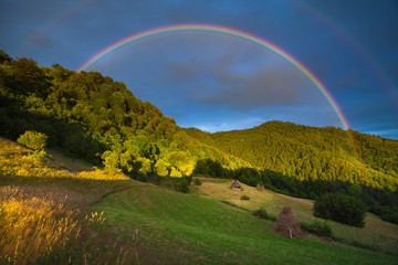 Scenic rainbow landscape on the hills in rural peaceful area