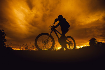 Mountain bike rider silhouette at sunset