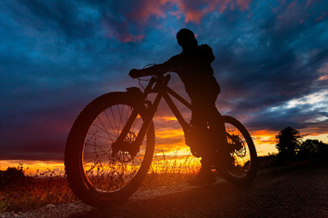 Mountain bike rider silhouette at sunset