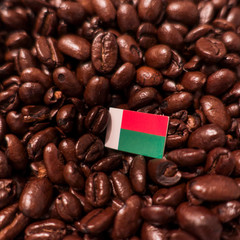 a Madagascar flag placed over roasted coffee beans