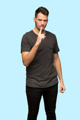 Man with black shirt frustrated and pointing to the front over blue background