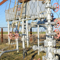 Grid the chain-link near an oil well.