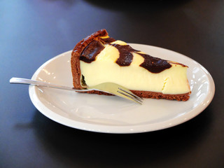 Cheesecake on white plate with fork.