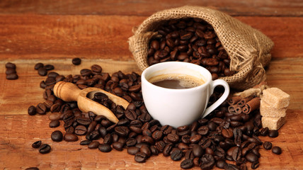 Coffee cup with Coffee beans, burlap sack and with cinnamon sticks