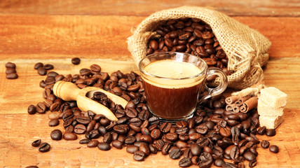 Coffee cup with Coffee beans, burlap sack and with cinnamon sticks