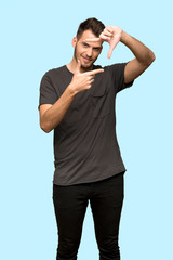 Man with black shirt focusing face. Framing symbol over blue background