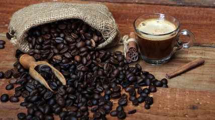 Coffee cup with Coffee beans, burlap sack and with cinnamon sticks