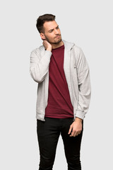 Man with sweatshirt thinking an idea while scratching head over grey background