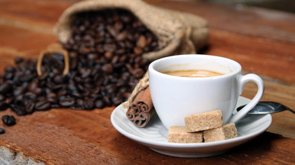 Coffee cup with Coffee beans, burlap sack and with cinnamon sticks