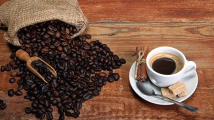 Coffee cup with Coffee beans, burlap sack and with cinnamon sticks