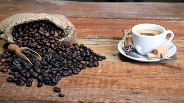Coffee cup with Coffee beans, burlap sack and with cinnamon sticks