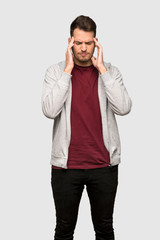 Man with sweatshirt with headache over grey background