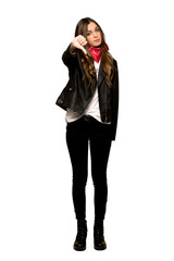Full-length shot of Young woman with leather jacket showing thumb down sign with negative expression on isolated white background