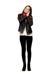 Full-length shot of Young woman with leather jacket making sleep gesture in dorable expression on isolated white background